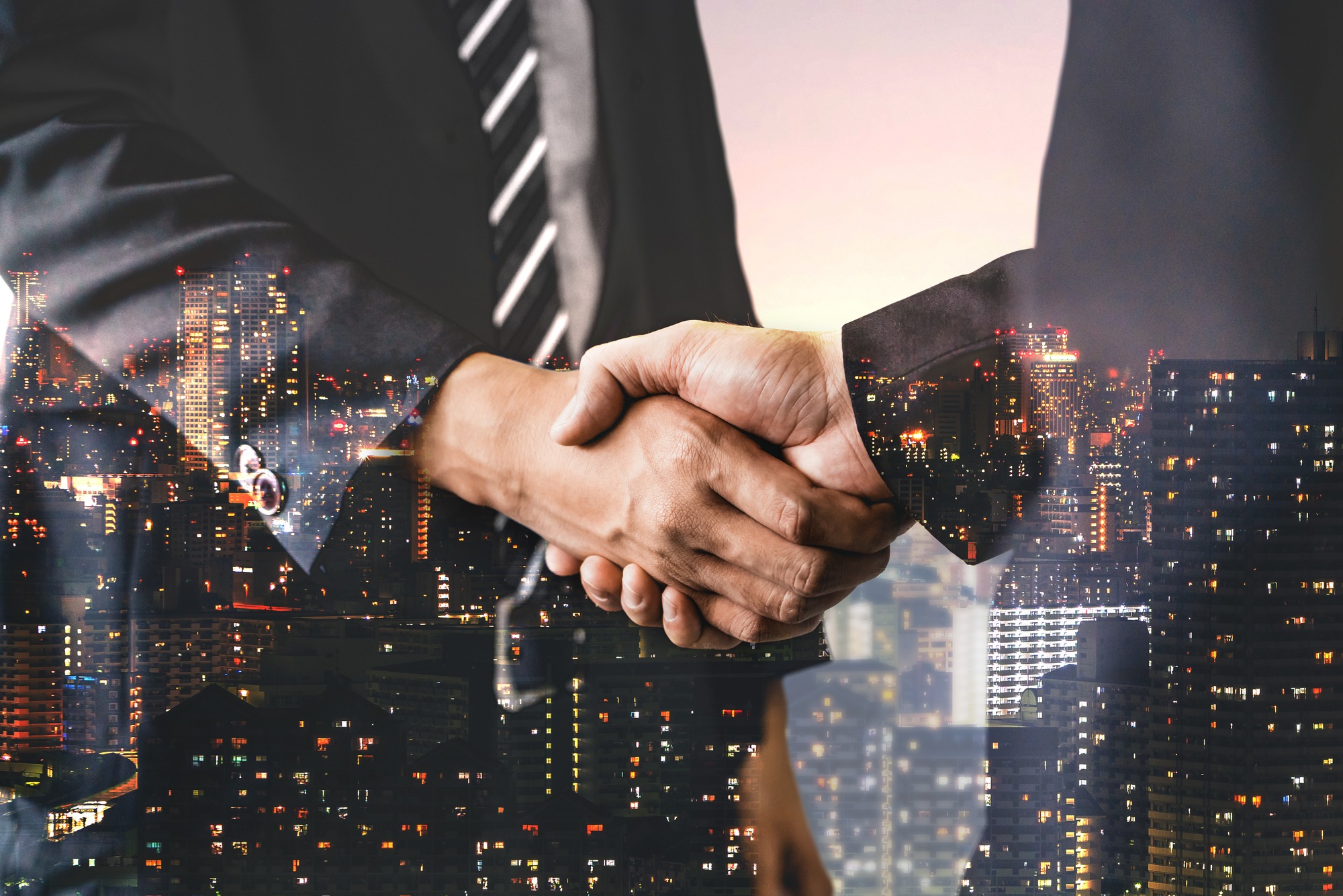 Double exposure image of business people handshake on city office building