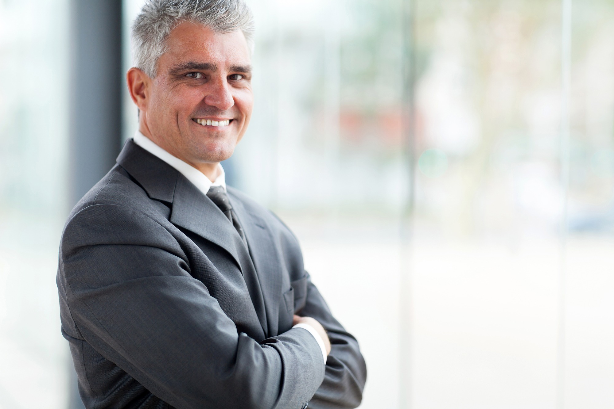 cheerful businessman with arms folded looking at the camera